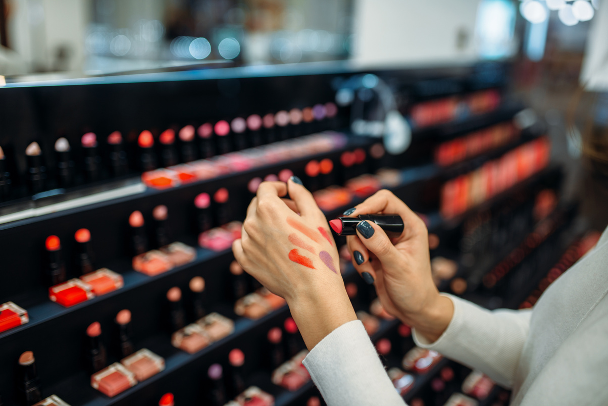 Female Customer Testing Lipstick in Make-up Shop